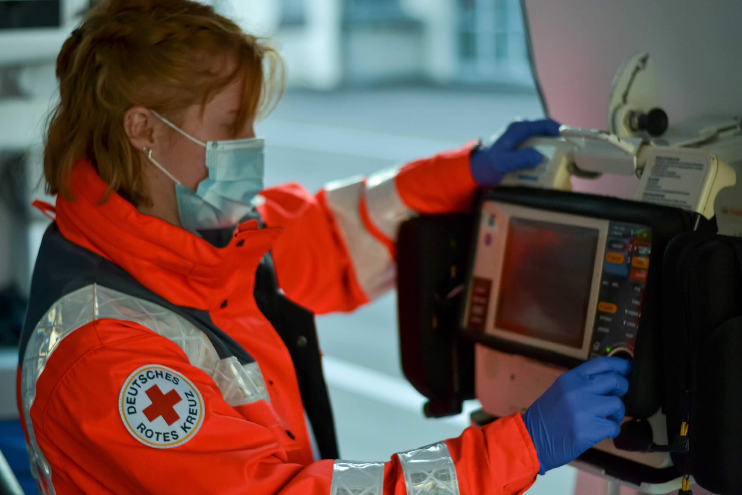Mitglied der BRK Bereitschaft Prien bedient den Patientenmonitor des Krankentransportwagens.